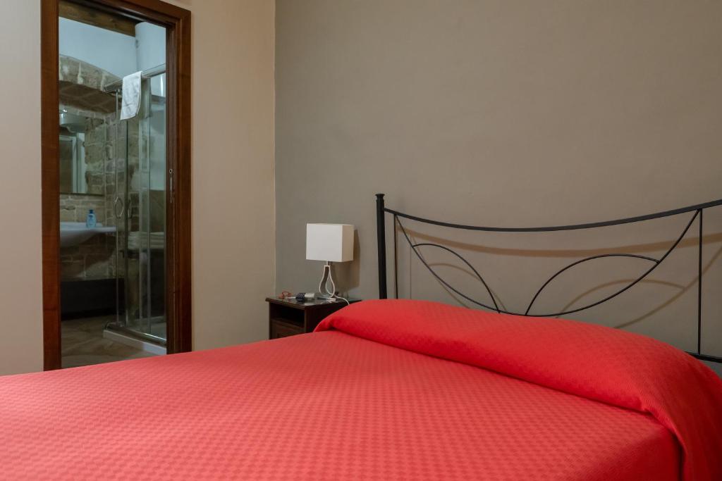 比通托B&B Santi Medici的一间卧室配有红色的床和红色毯子