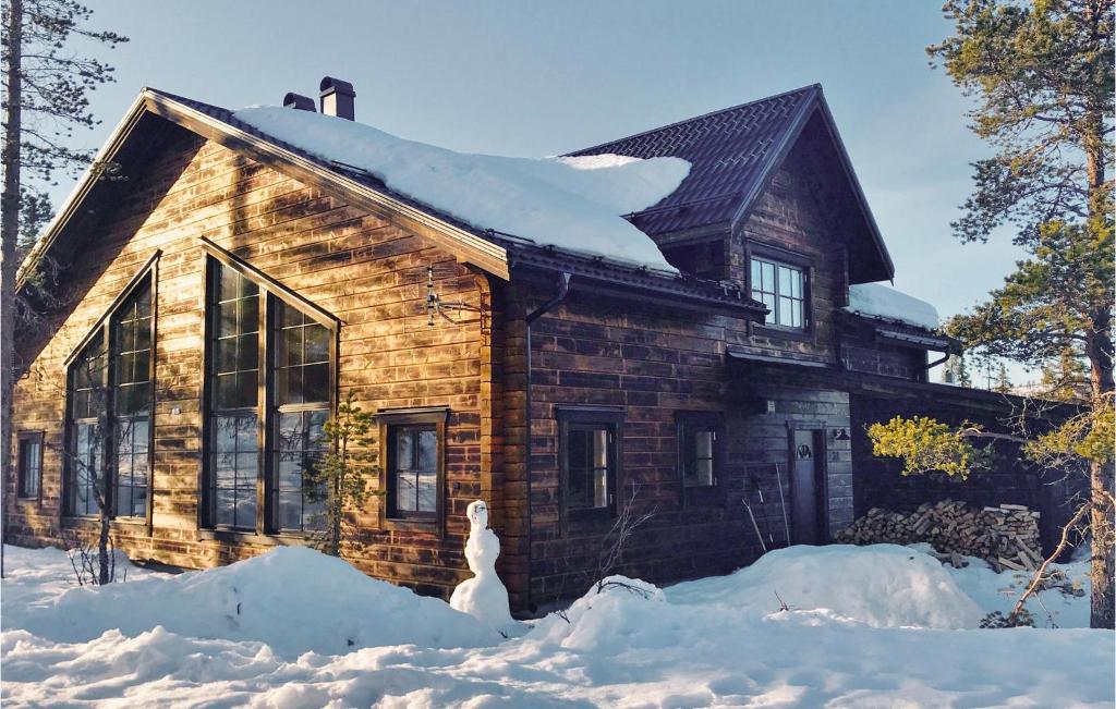 韦姆达伦Amazing Home In Vemdalen With Wifi的小木屋前面的地面上有雪