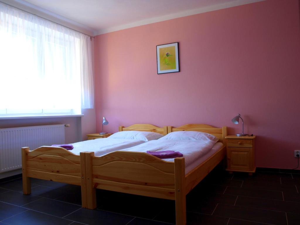 DrnholecPenzion U Dvou lip的一间卧室配有一张床和粉红色的墙壁