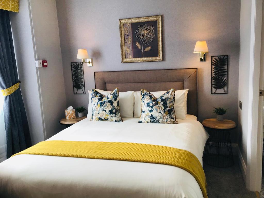 斯卡伯勒The Alexander的一间卧室配有一张大床,提供黄色和蓝色的枕头