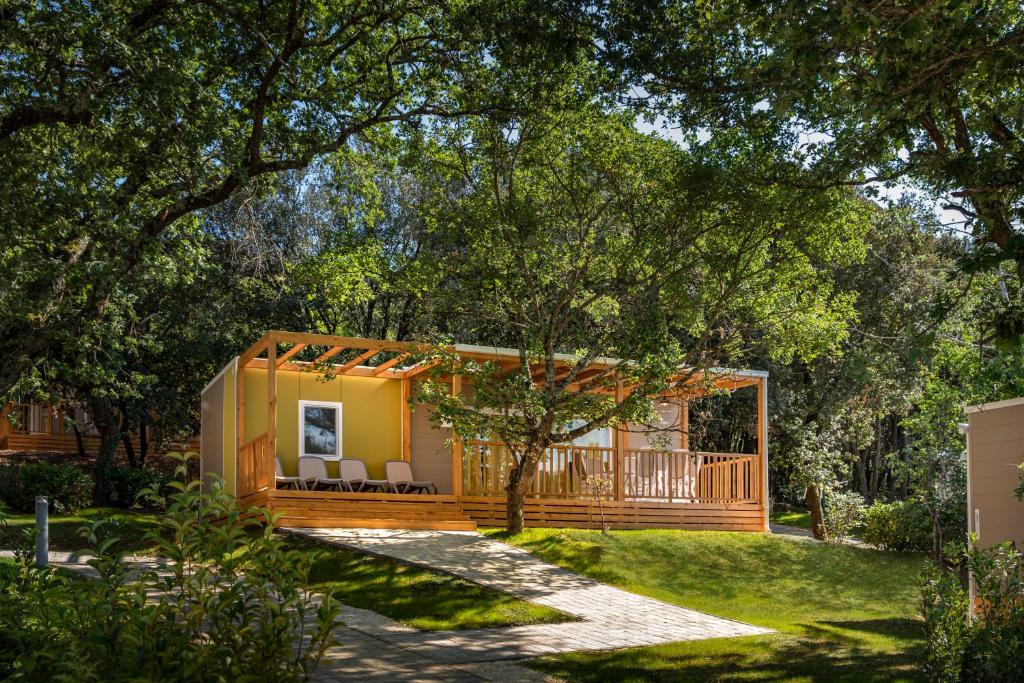 弗尔萨尔Maistra Camping Porto Sole Mobile homes的花园中的一个小房子,有门廊