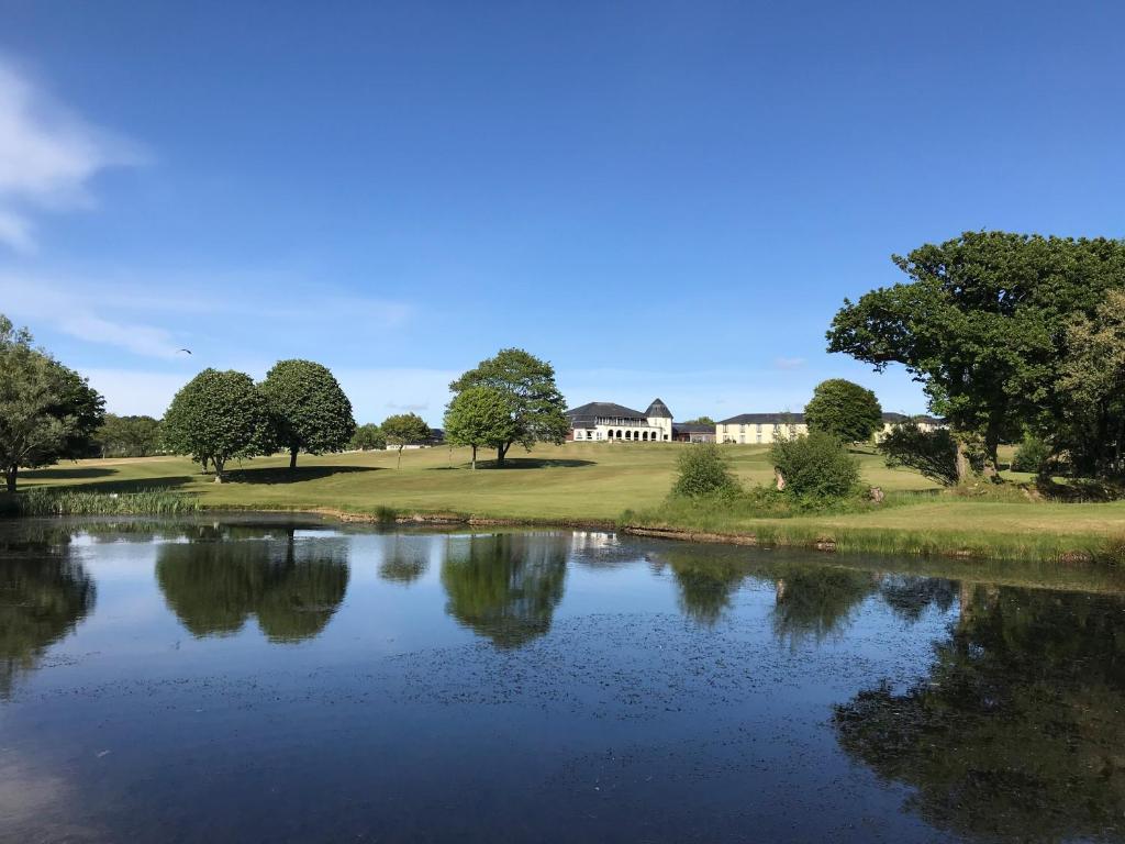 博德明兰海德罗克高尔夫俱乐部酒店的房屋前池塘的景色
