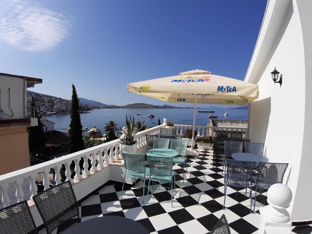 萨兰达Bistrica Hotel的阳台配有桌椅和遮阳伞。