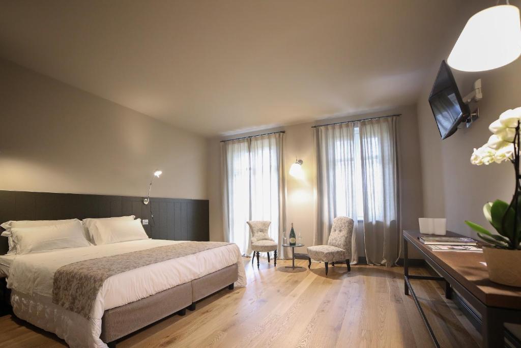 阿斯蒂Locanda Ferro UNO, Golf Città di Asti的卧室配有一张床、一张桌子和椅子