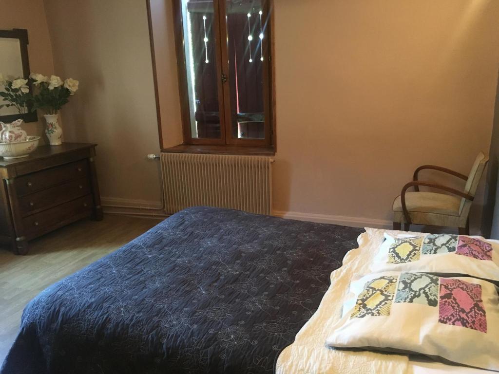 拉翁莱塔普Le Jolis Bois的卧室配有床、椅子和窗户。