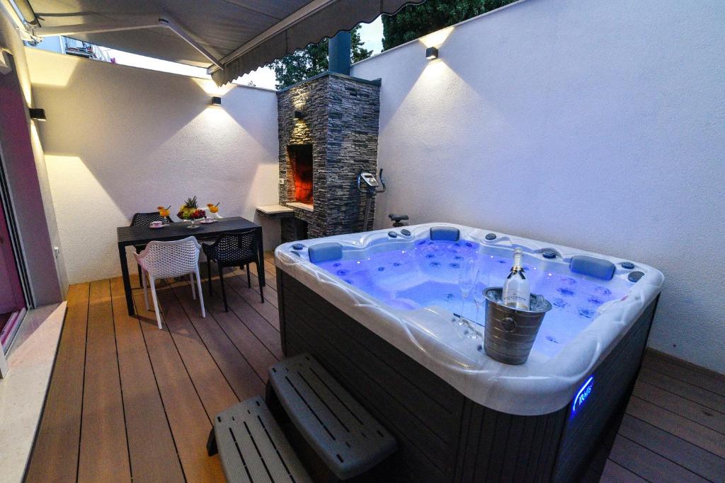锡尼Luxury Apartment Knezovic的甲板上的按摩浴缸,配有桌子