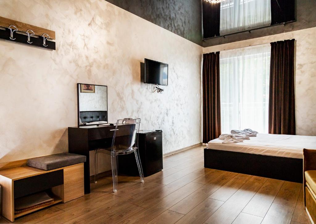扬博尔family hotel - City hotel yambol的酒店客房带一张床铺、一张书桌和一间卧室
