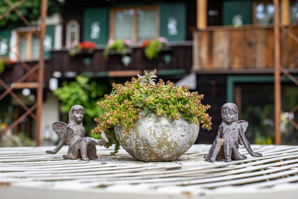韦尔芬Alpenrelax Haus Weidmannsheil wohnen im romantischen Forsthaus的盆栽植物旁边桌子上的三个雕像