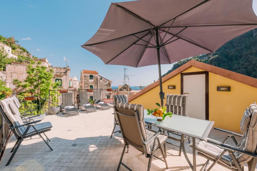 阿马尔菲Bouganville Holiday house Amalfi的庭院内桌椅和遮阳伞