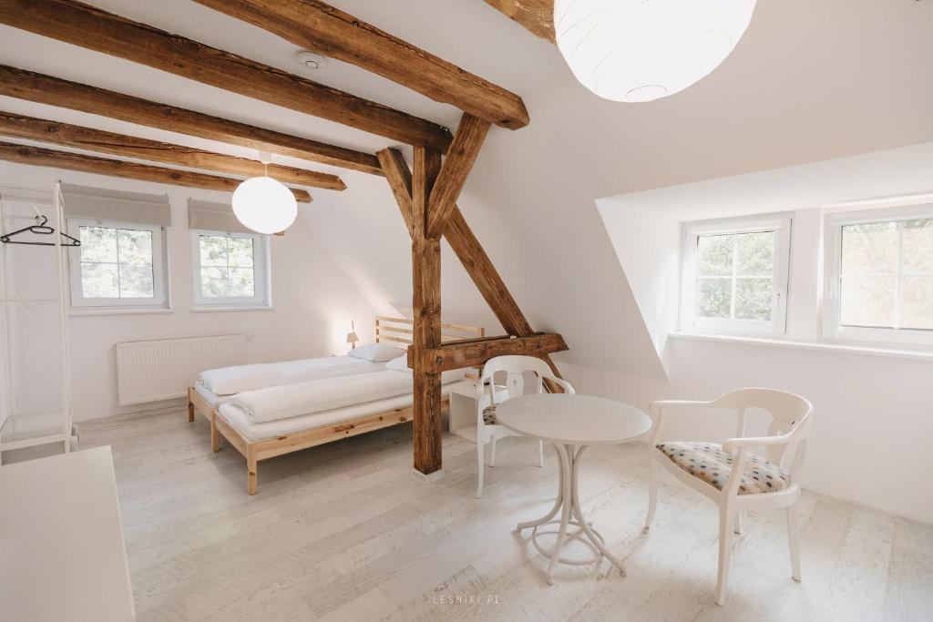 BabimostLeśniki的卧室配有一张床和一张桌子及椅子
