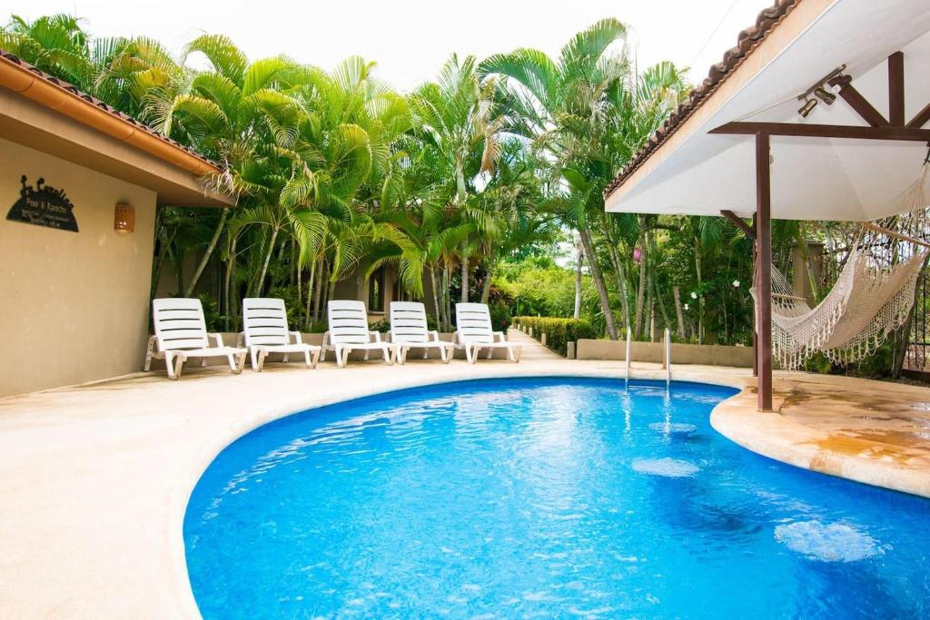 巴希利托Charming unit that sleeps 4 - with pool - walking distance from Brasilito Beach的一个带椅子和遮阳伞的游泳池