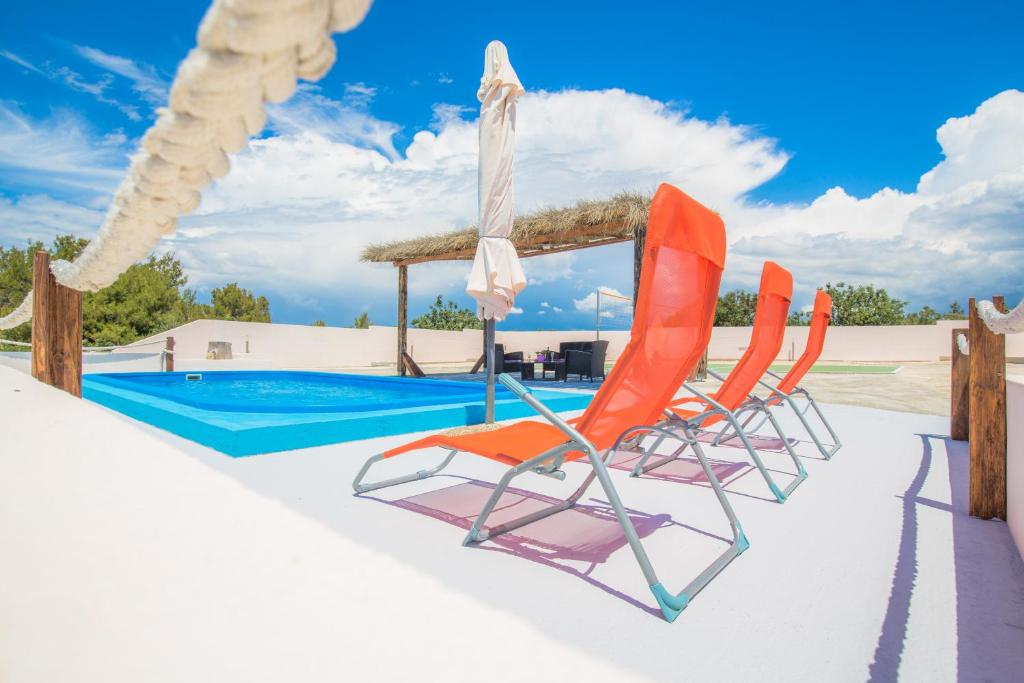 普利莫顿Holiday House El Dorado!!的两把椅子和一个遮阳伞以及一个游泳池
