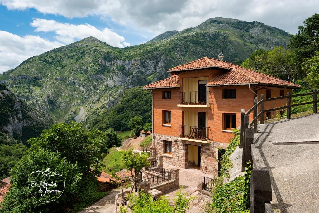 NavedoEl Mirador de Jozarcu的山丘上以山为背景的房子