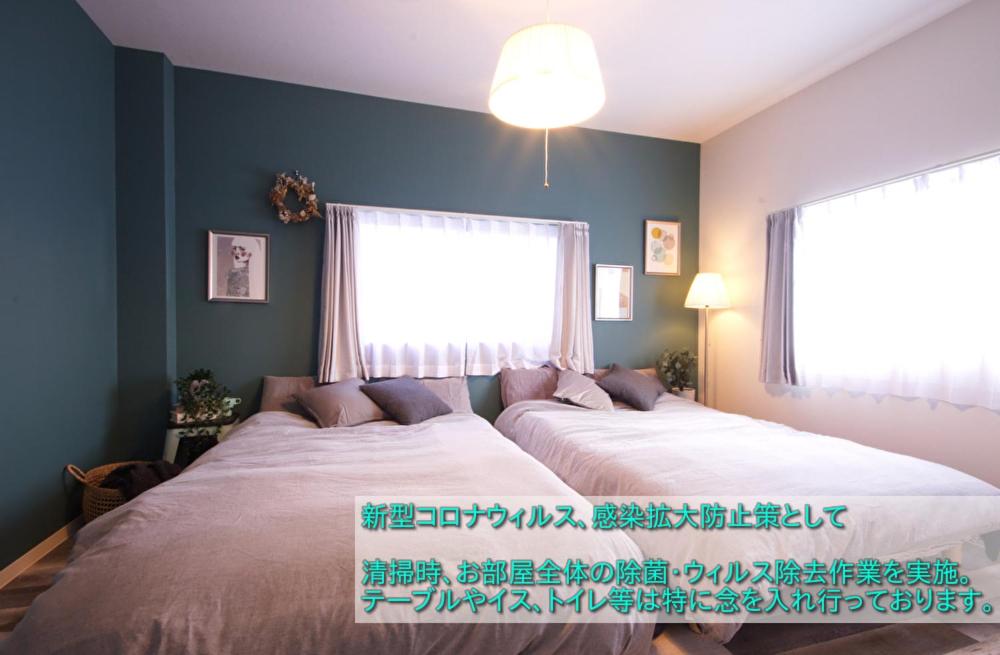 名古屋Guest House Re-worth Joshin1 3F的一间卧室设有一张大床和一个窗户。