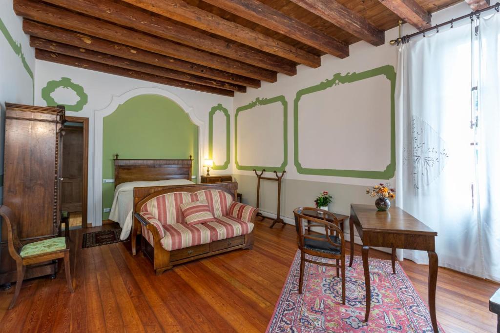 PolcenigoPalazzo Scolari的一间卧室配有一张床、一张桌子和一把椅子
