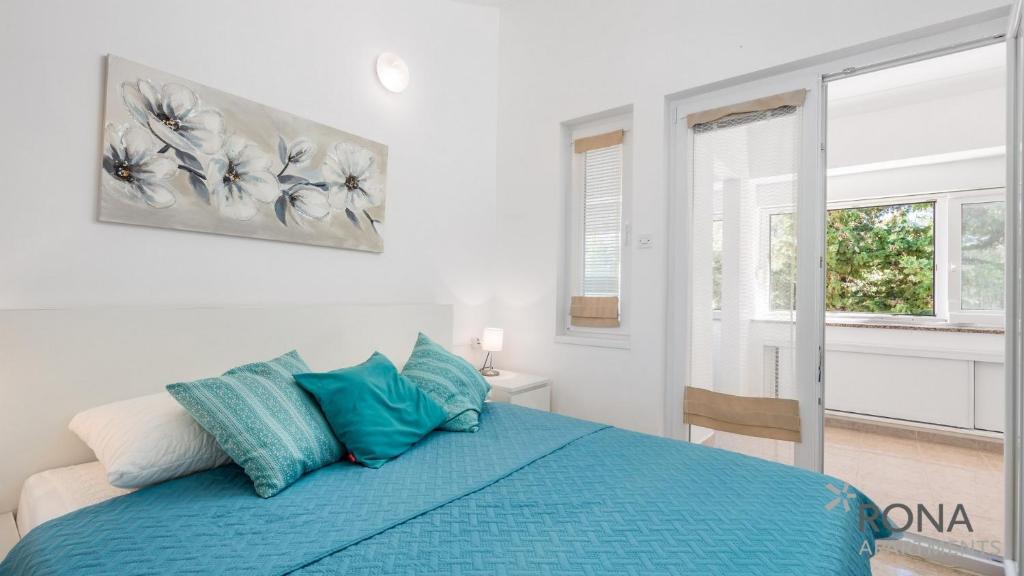诺瓦利娅Rona Apartment Flower 1 and Flower 2的一间卧室设有蓝色的床和窗户。