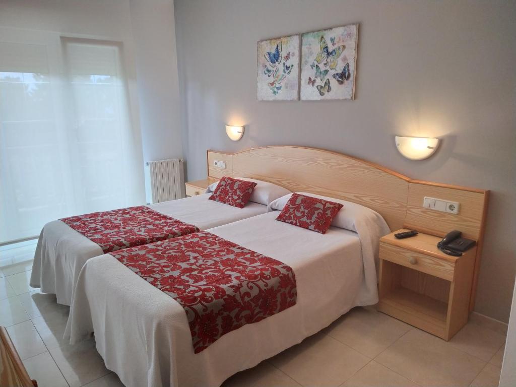 BaleaPension Playa Mar Cachadiñas的一间卧室配有一张带红色毯子的大床