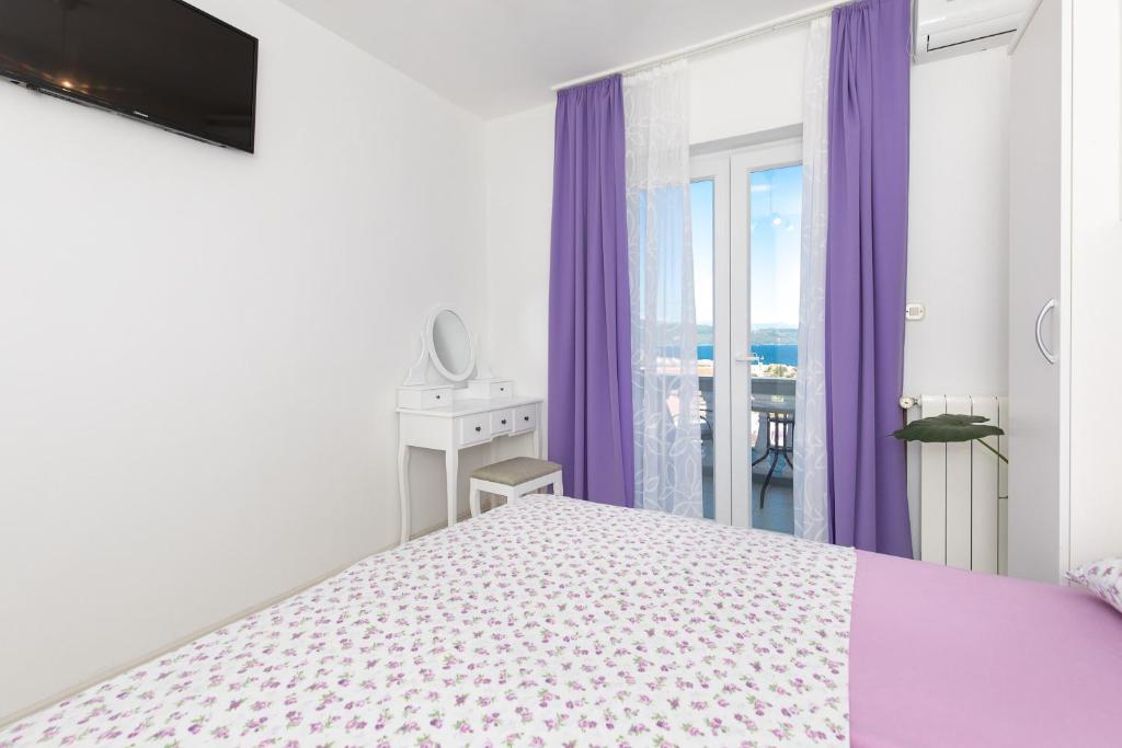 克尔克Apartment & rooms Ivica的白色卧室配有紫色窗帘和1张床