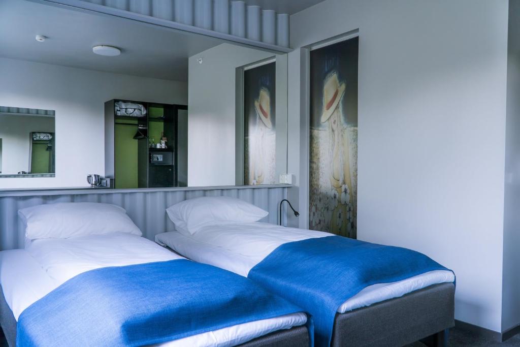 斯塔姆松Live Lofoten Hotel的两张睡床彼此相邻,位于一个房间里