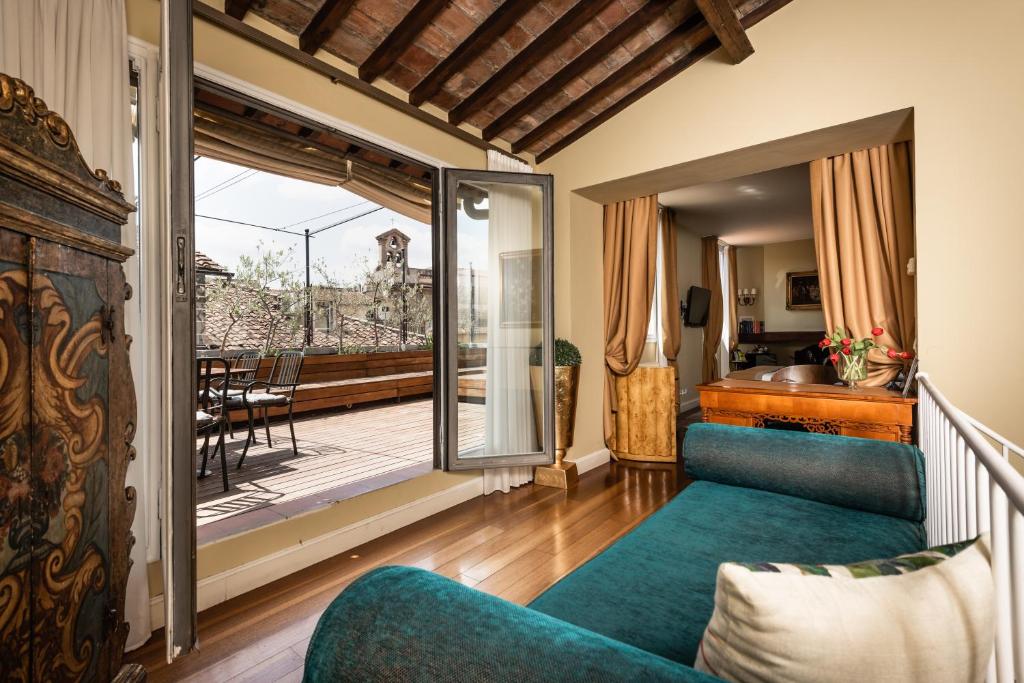 佛罗伦萨AQA Palace的一间带蓝色沙发的客厅和一个阳台