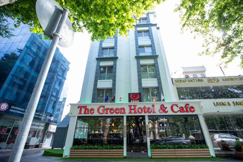 伊斯坦布尔THE GREEN HOTEL的绿色的酒店和咖啡馆,位于大楼前