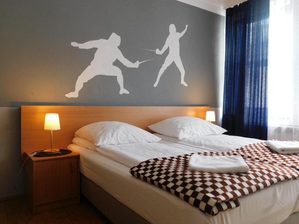 克拉科夫珀考叶高斯娜可若娜酒店的一间卧室,配有一张带墙壁的床,里面的人都坐在墙上