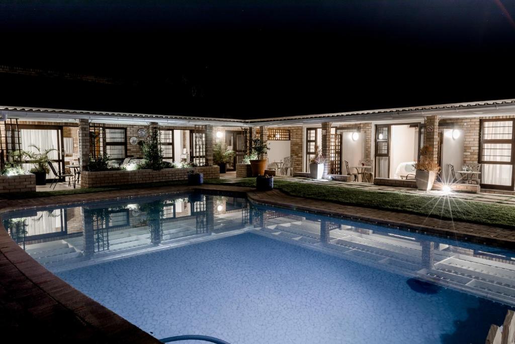 伊丽莎白港Wagtails Guest House的夜间在房子前面的游泳池