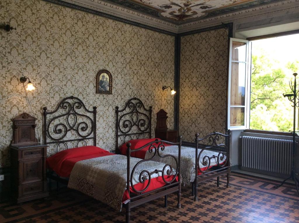 萨尔扎纳Villa Carlotta的一间卧室配有一张带红色床单的床和一扇窗户。