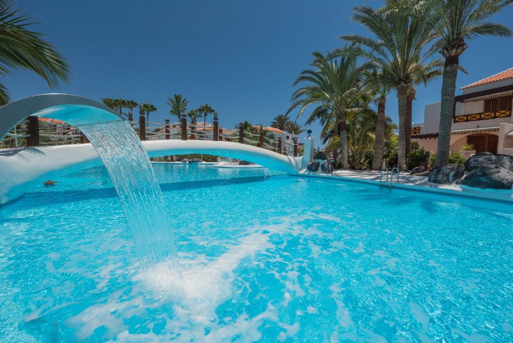 美洲海滩Parque Santiago 3 Luxery Apartment, Playa las Américas, Arona, Tenerife的度假村内带喷泉的游泳池