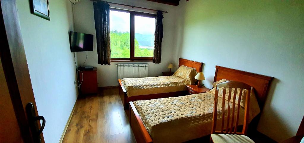 ShilkovtsiComplex Pristan in the mountain的一间卧室设有两张床和窗户。