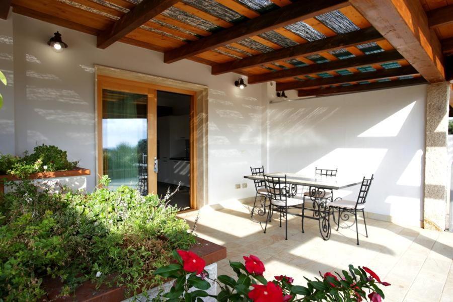 阿尔盖罗Cala Azul Residence B&B的庭院配有桌椅和鲜花