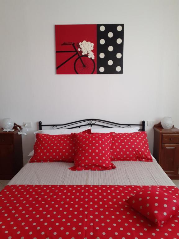 维拉西米乌斯B&B MARZO '51的一张带红色和白色的polka 圆顶枕头的床
