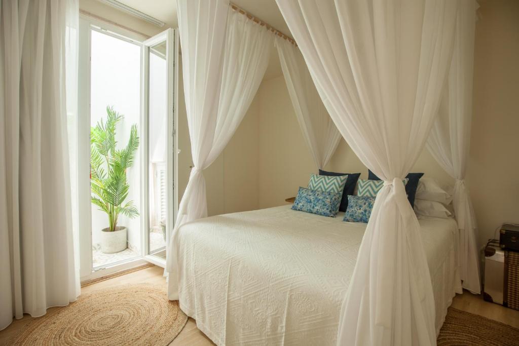 塞图巴尔Ana´s House的一间卧室配有一张天蓬床和窗户