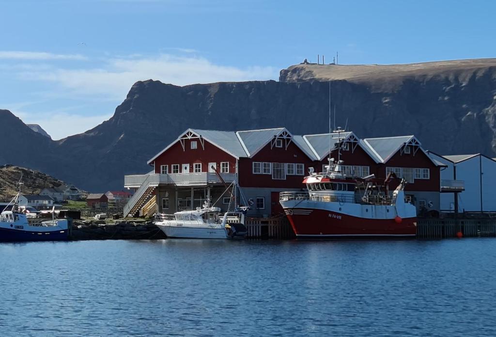 VærøyBensvik Brygge的两艘船停靠在水中,靠近一座房子