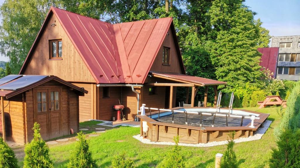 兹拉特霍里Chata Osmička的一座带红色屋顶和热水浴池的房子