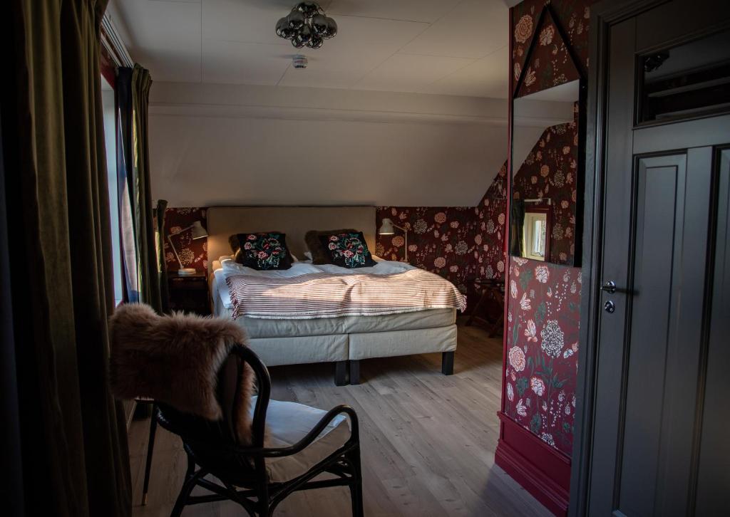 ForsvikVilla Göta的一间卧室配有一张床、一把椅子和镜子
