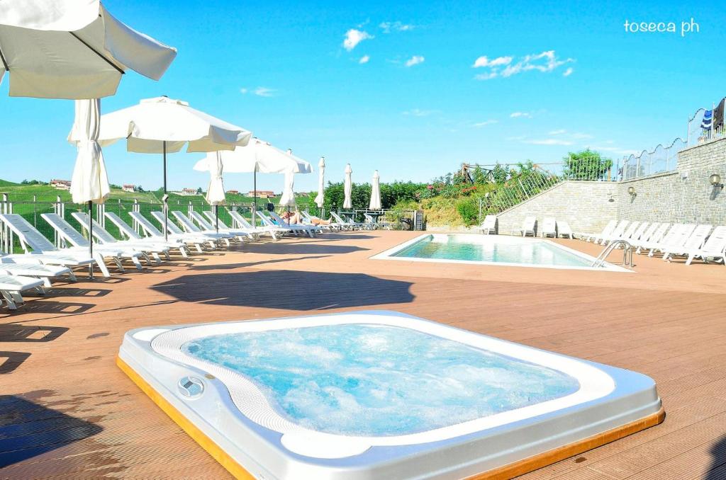 巴巴莱斯科卡萨尼可里尼酒店的一个带椅子和遮阳伞的大型游泳池