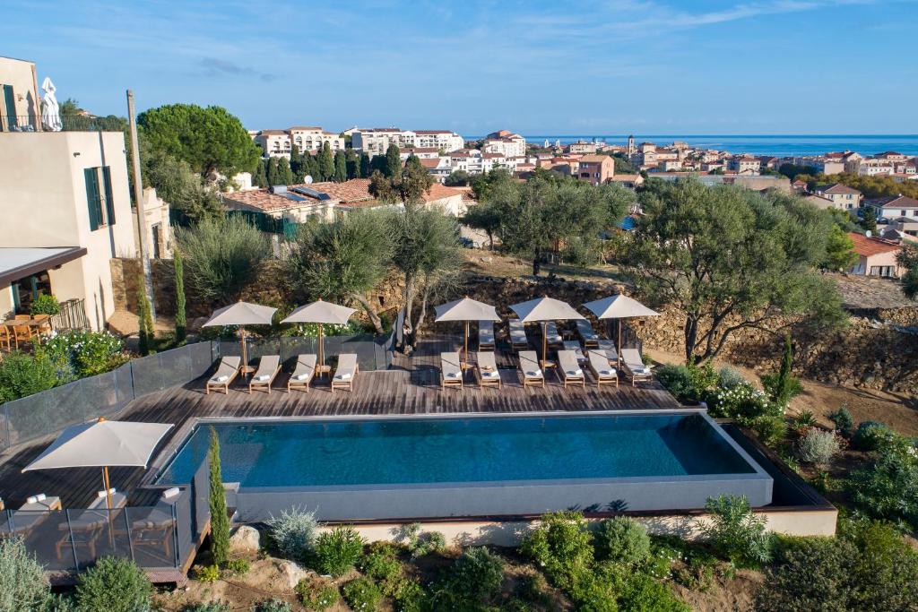利勒鲁斯Hôtel Restaurant Villa Joséphine的享有游泳池的空中景致,配有椅子和遮阳伞