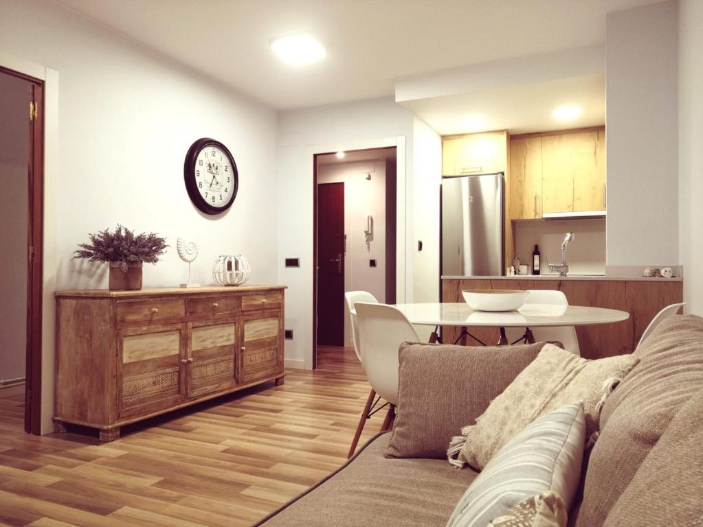 卡隆赫Apartamento Can CALET con PARKING en Sant Antoni de Calonge的客厅以及带沙发和桌子的厨房。
