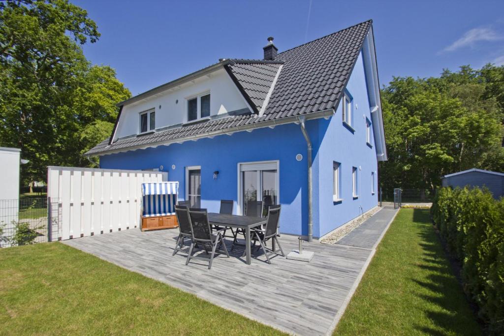布雷格Ferienhaus Luna Haus - Terrasse, Garten, Sauna的蓝色的房子,甲板上配有桌椅