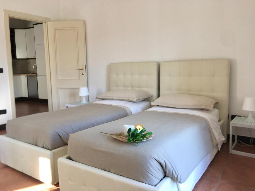 拉帕洛La casa di Giulia Apartment with air conditioning, wifi and private parking的卧室内的两张床,带一盘鲜花