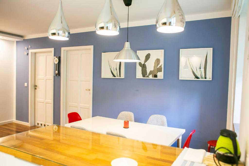 塔尔努夫Best Apartment的一间拥有蓝色墙壁和桌椅的用餐室