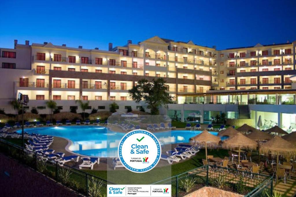 阿尔布费拉山海大西洋景花园酒店的一座带游泳池和椅子的酒店和一座建筑