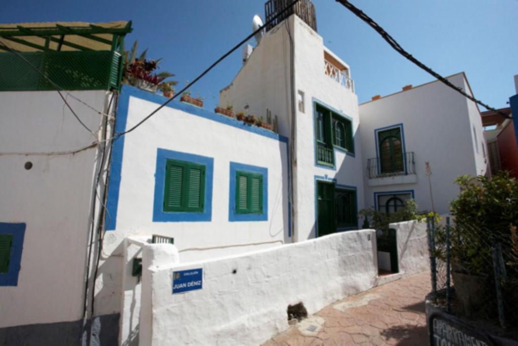 莫甘海滩Captains House Playa De Mogan的白色的建筑,上面有绿色百叶窗