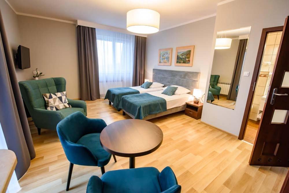 克雷尼察加里西亚培训和度假酒店的酒店客房带一张床、一张桌子和椅子