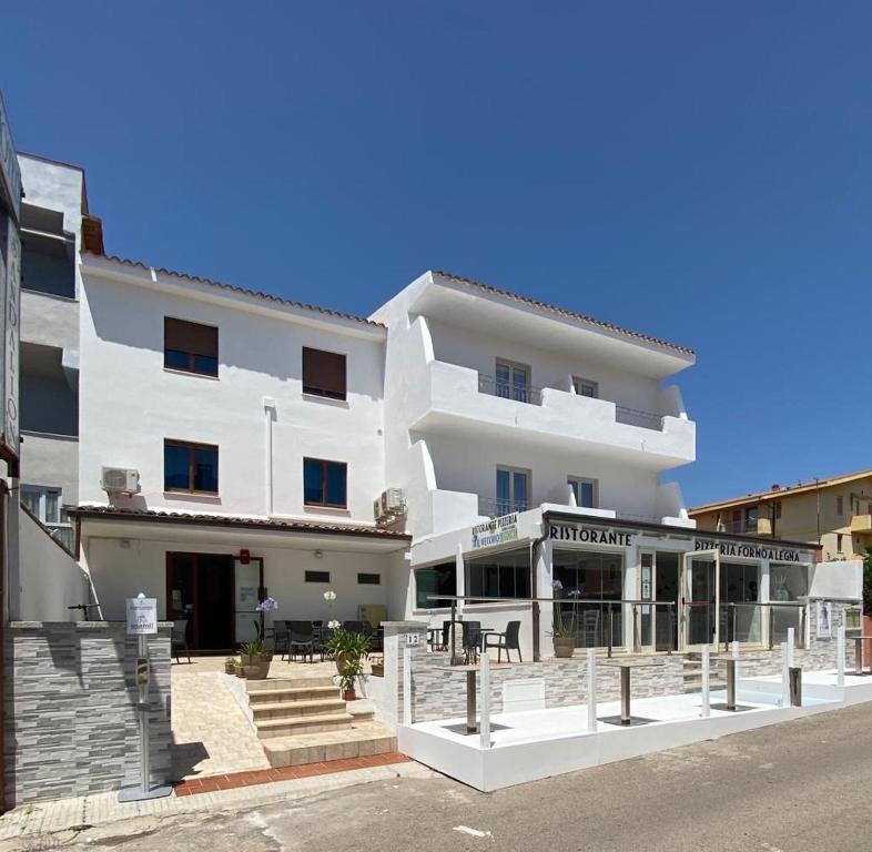 圣特雷莎加卢拉圣达里昂酒店的一座白色的建筑,前面有一间餐厅