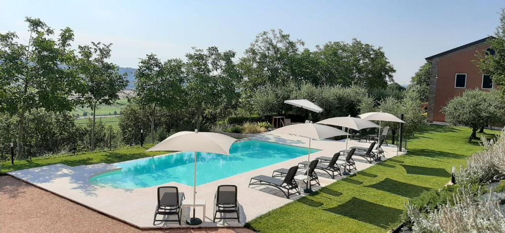 圣马尔蒂诺博纳尔贝尔戈卡德克茨住宿加早餐旅馆的庭院内带椅子和遮阳伞的游泳池