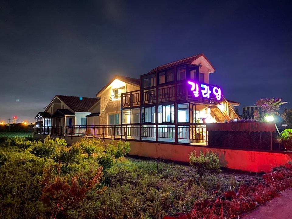 济州市济州吉琳住宿加早餐旅馆的上面有 ⁇ 虹灯标志的房子