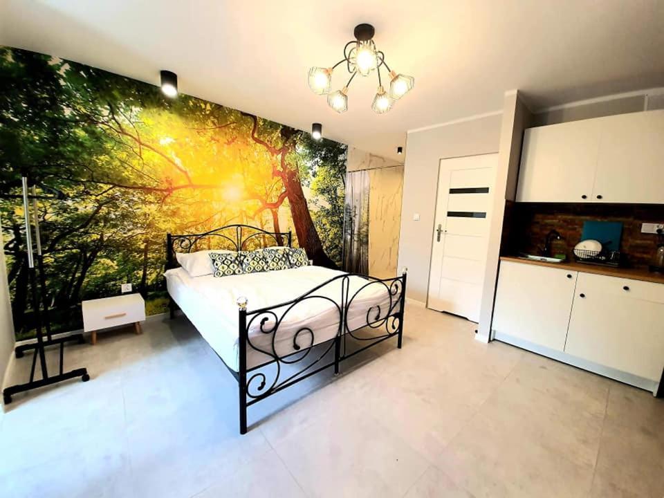 奥古斯图Apartamenty w Puszczy的一间卧室配有一张壁画床