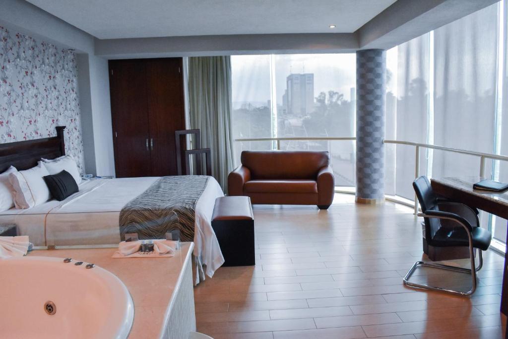 瓜达拉哈拉波托韦洛酒店的酒店客房设有床、水槽和浴缸。